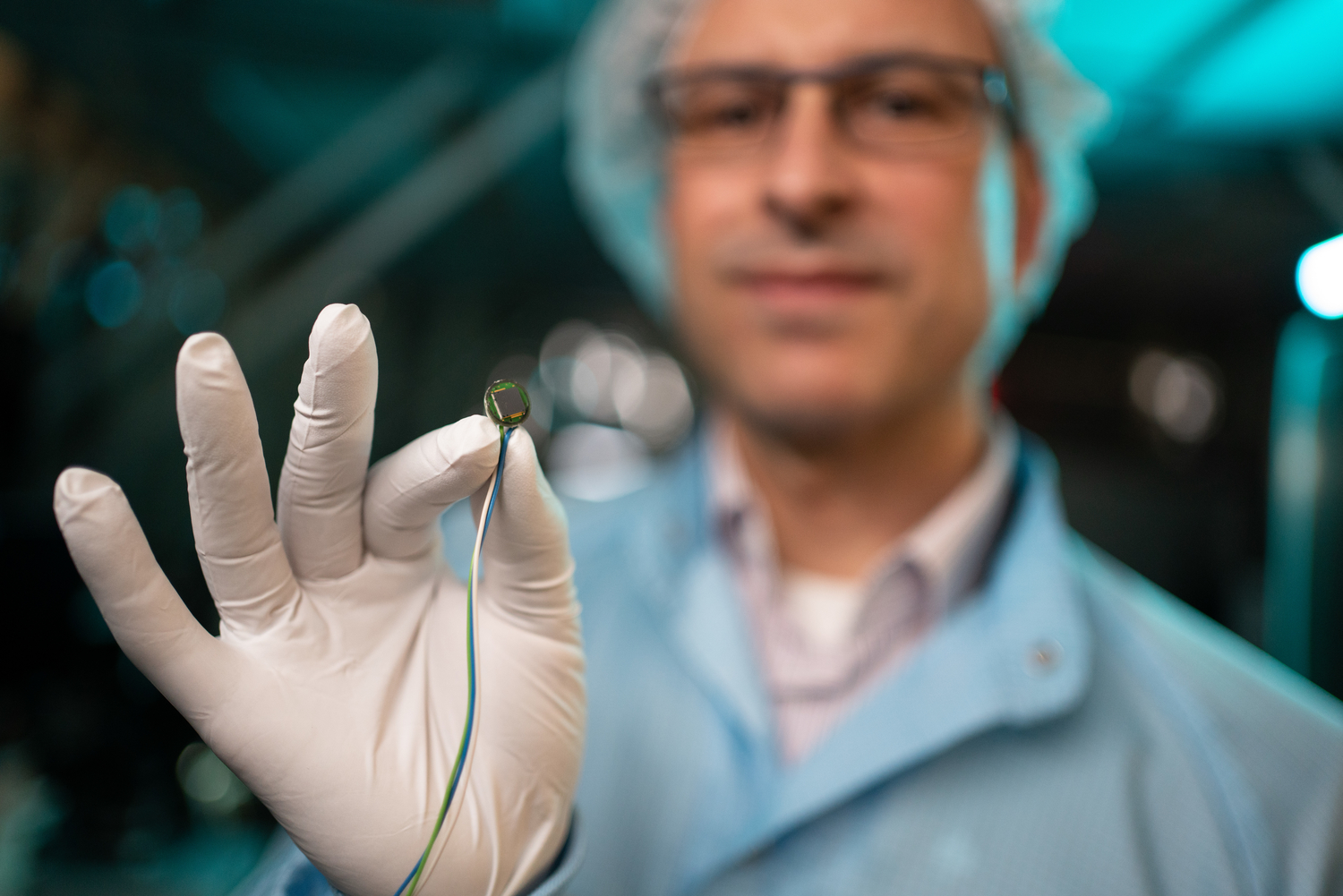 Prof. Dr.-Ing. Dr. rer. nat. habil. Harald Schenk, Leiter des Fachgebiets Mikro- und Nanosysteme, im Reinraum mit einem Mikrochip Foto: BTU / Sebastian Rau